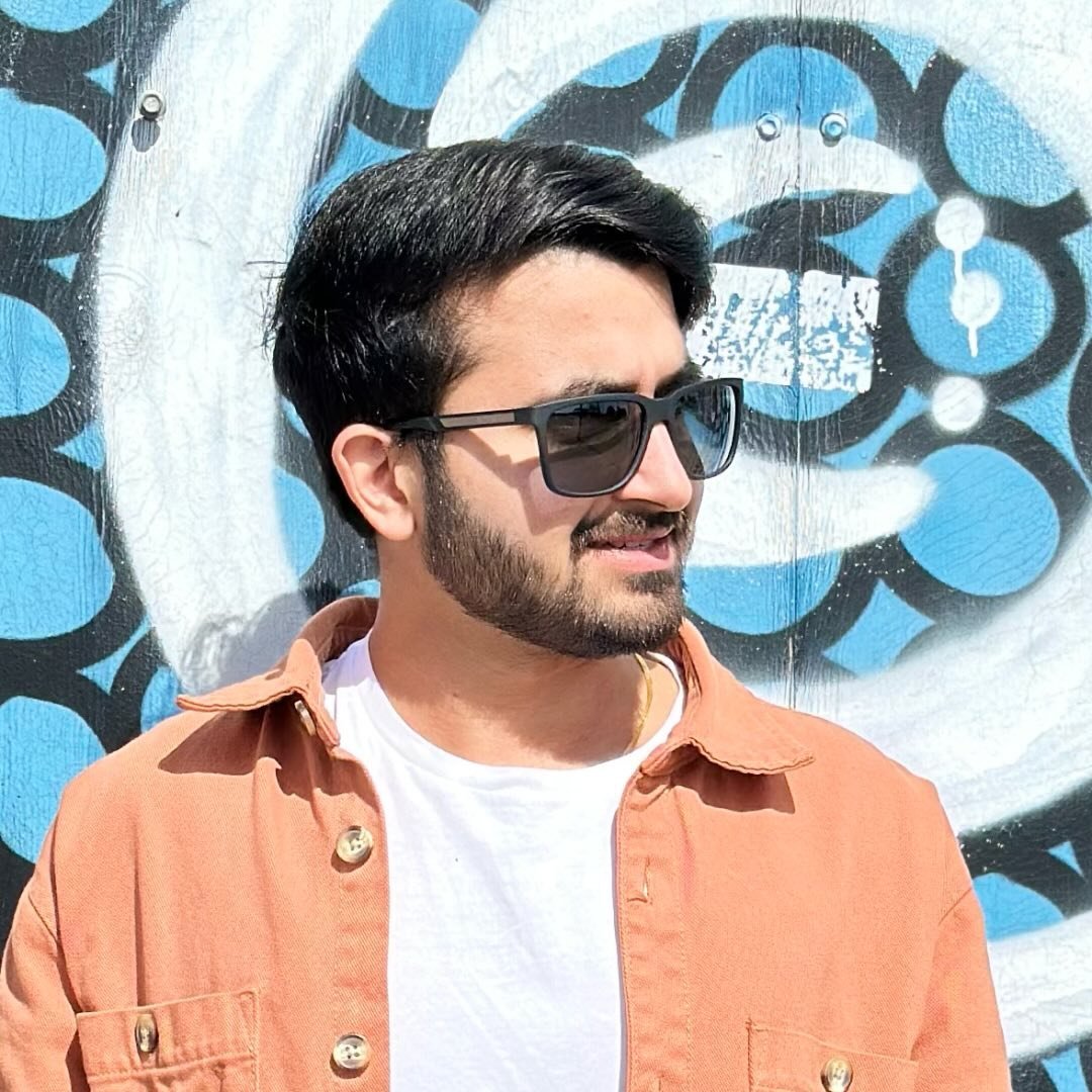 Ankit, creator of WHATIFANKIT, standing in front of a painted wall